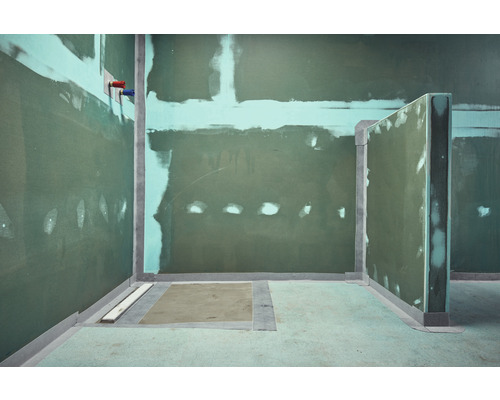 Salle de bain non terminée avec murs en plaques de plâtre et élément de sol