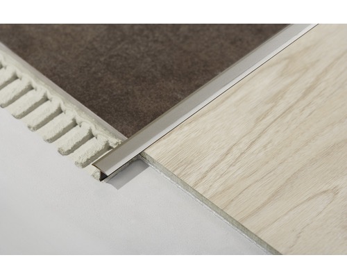 Installation de revêtement de sol avec rail de carrelage entre le carrelage et le plancher en bois