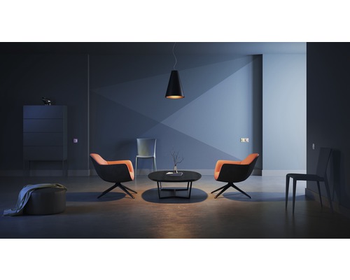 Wohnzimmer mit zwei Sesseln, einem Couchtisch, einer Hängeleuchte und einem Sideboard