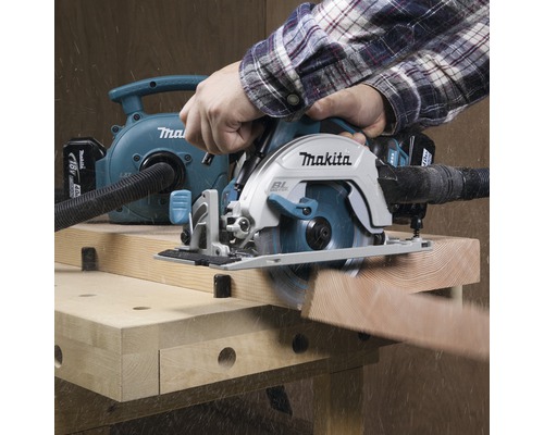Scie circulaire portative Makita avec aspiration de poussière en utilisation sur un établi