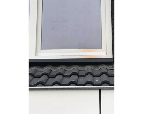 Vue détaillée d''un toit avec des tuiles et une fenêtre.