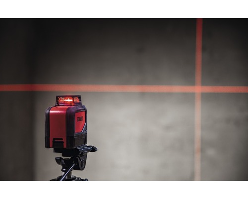 Kreuzlinienlaser auf Stativ mit Laserlinien an der Wand