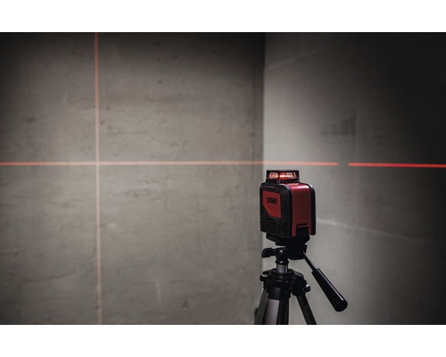 Roter Kreuzlinienlaser auf Stativ projiziert Linien an eine Wand
