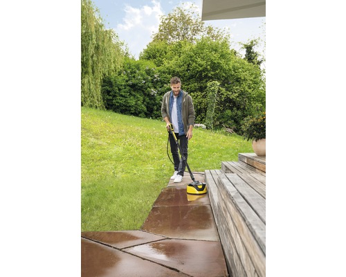 Homme nettoie la terrasse avec un nettoyeur de terrasse