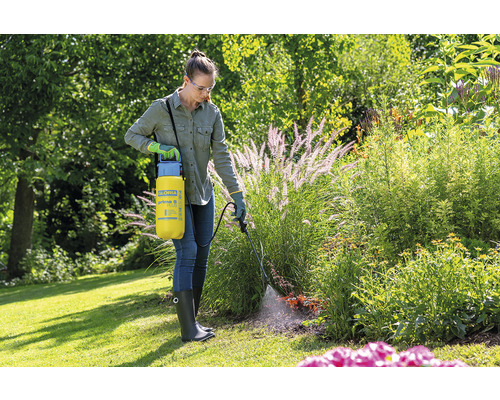 Frau verwendet Gloria Prima 5 Plus Drucksprüher im Garten zur Pflanzenpflege