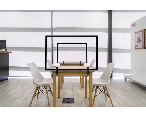 Tables avec écrans de protection transparents et chaises dans un bureau