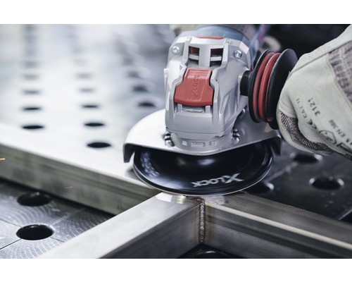 Eine Person verwendet einen Winkelschleifer zum Schleifen eines Metallstücks.