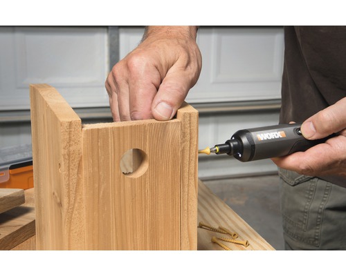 Eine Person benutzt einen Schraubendreher zum Zusammenbau eines hölzernen Vogelhauses.