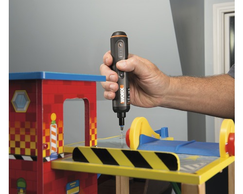 Eine Person benutzt einen Akku-Schraubendreher auf einem Spielzeug.