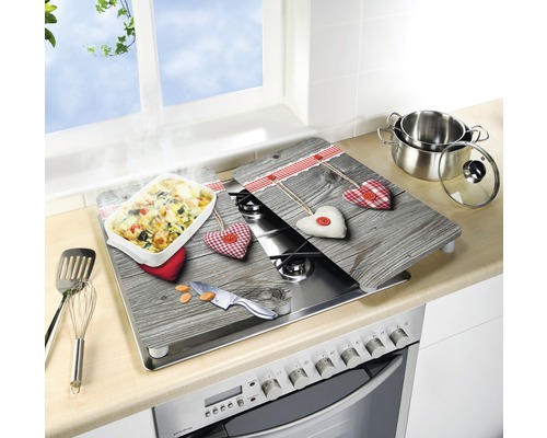 Plaques de recouvrement de cuisinière avec aspect bois et motifs de cœur sur une cuisinière avec des ustensiles de cuisine