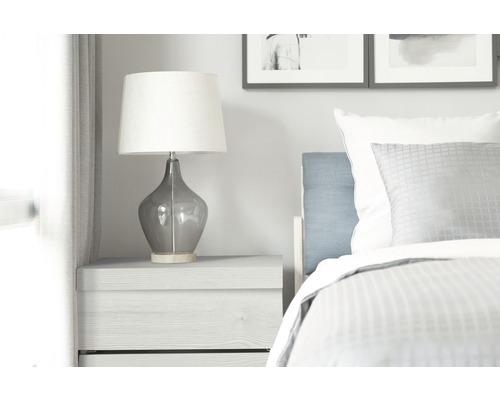 Nachttisch mit Lampe und Bett im Schlafzimmer