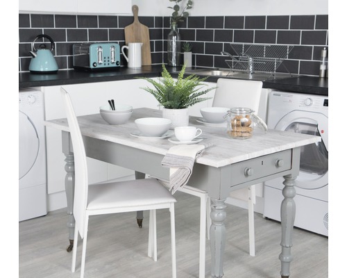 Table de salle à manger avec vaisselle et chaises dans une cuisine