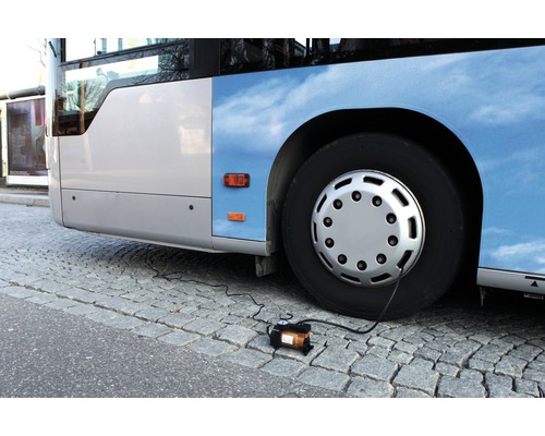 Reifen eines Busses wird mit einem Kompressor aufgepumpt