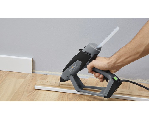 Heissklebepistole beim Anbringen einer Holzleiste