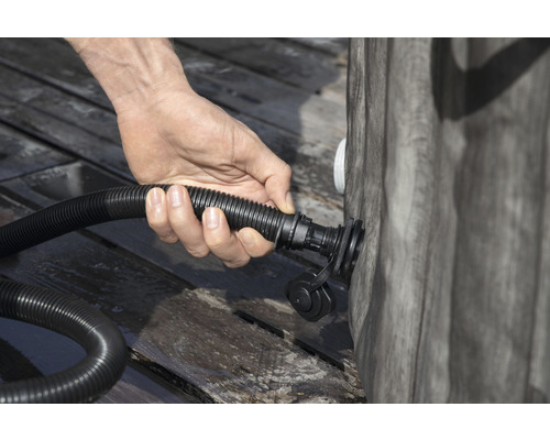 Eine Person schliesst einen Schlauch an einen Pool an.