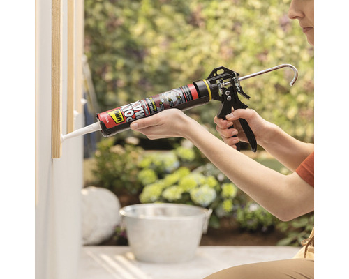 Une personne utilise un pistolet à cartouche pour appliquer du mastic