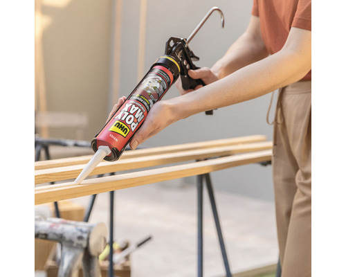 Une personne utilise un pistolet à cartouche pour appliquer de la colle sur des lattes en bois