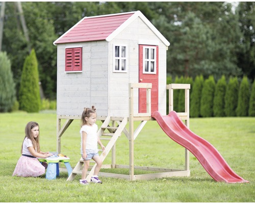 Maisonnette avec toboggan et deux enfants jouant dans le jardin