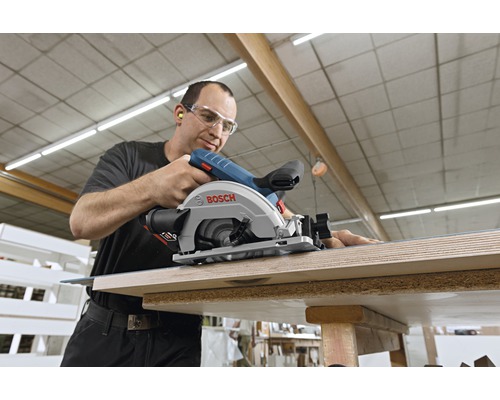 Un homme utilise une scie circulaire portative Bosch pour couper du bois.