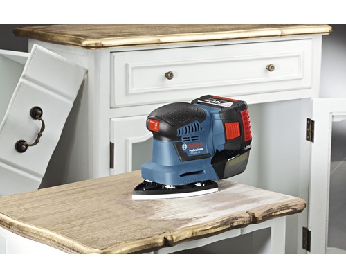 Ponceuse excentrique sans fil ponçant une commode