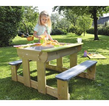 Enfant jouant à une table à sable et à eau avec des bancs de jardin.