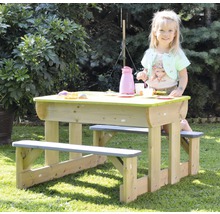 Enfant assis à une table de pique-nique avec des bancs dans le jardin.