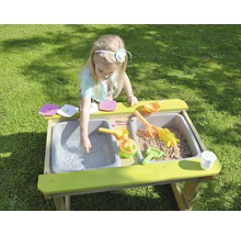 Fille jouant à la cuisine de boue avec du sable et de l''eau dans le jardin