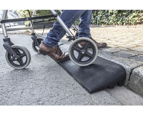 Person mit Rollator benutzt eine Bordsteinrampe für den Übergang