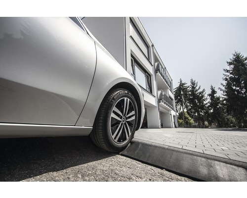 Ein Auto mit einem Michelin Reifen steht am Straßenrand vor einem Gebäude.