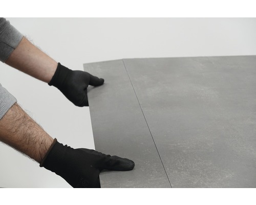 Person mit Handschuhen verlegt Bodenbelag