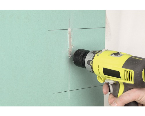 Perceuse perçant un trou dans une plaque de plâtre