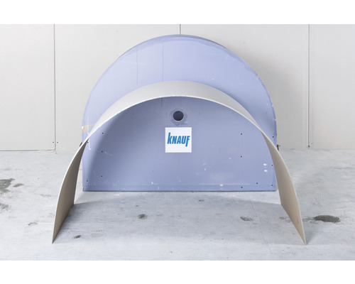 Plaque de plâtre cintrée devant une plaque de plâtre semi-circulaire avec le logo Knauf