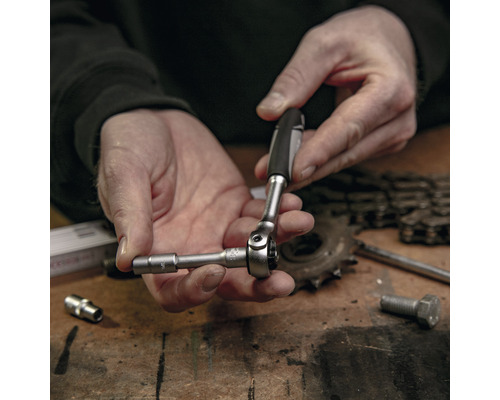 Gros plan d''une personne utilisant une clé à douille pour serrer une vis.
