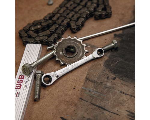 Situation d''atelier avec clé, vis, chaîne, engrenage et mètre pliant