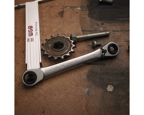 Clé à cliquet, engrenage, vis et mètre pliant sur un établi