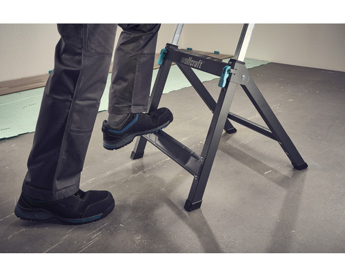 Une personne se tient sur une table de travail Wolfcraft.