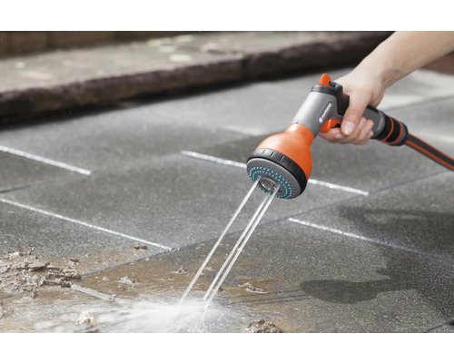 Lance d''arrosage de jardin en cours d''utilisation pour nettoyer une terrasse