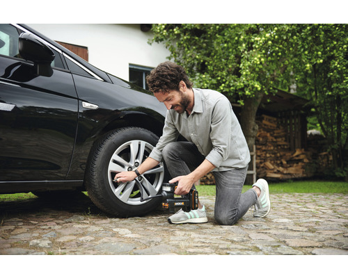 Ein Mann befüllt einen Autoreifen mit einem Reifenfüller von Worx.