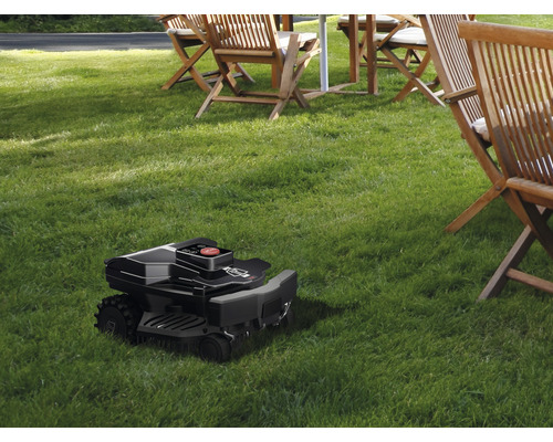 Rasenroboter auf Rasenfläche mit Gartenmöbeln