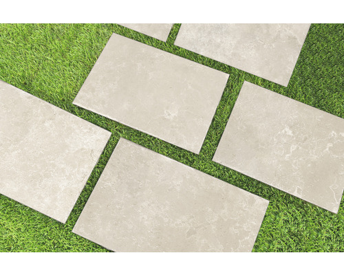 Rechteckige Terrassenplatten aus Stein auf Rasen