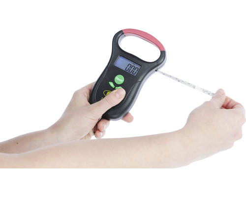 Une personne utilise un pèse-bagage numérique avec fonction thermomètre