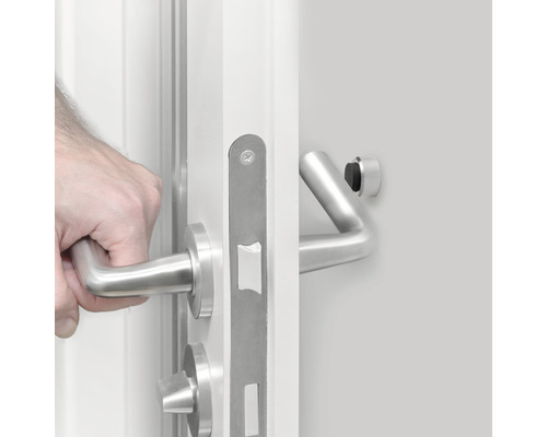 Hand öffnet weiße Tür mit Edelstahlbeschlägen
