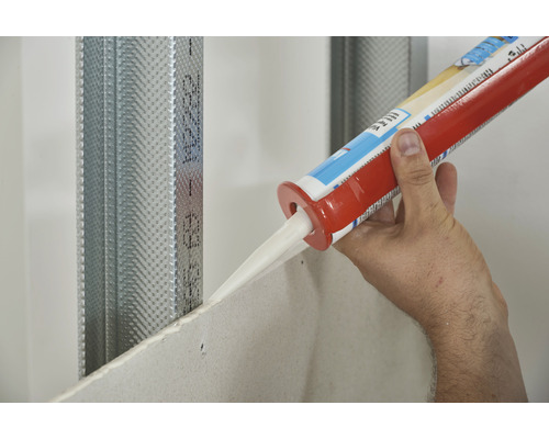 Eine Person trägt Dichtstoff auf eine Gipskartonplatte auf
