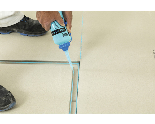 Auftragen von Klebstoff auf eine Duschrinne