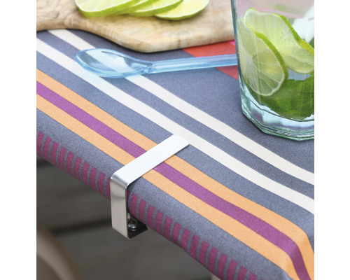 Tisch mit Tischdecke, Limettenscheiben, Getränk und einem Tischdeckenhalter aus Metall