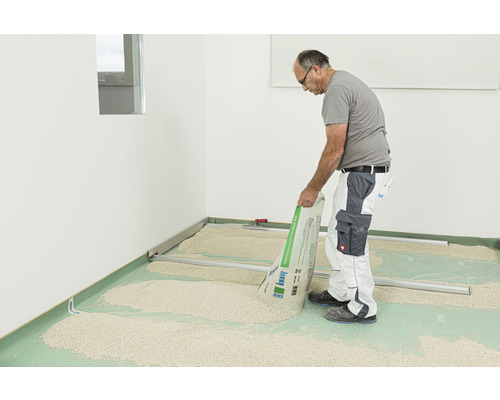 Handwerker schüttet Trockenschüttung auf dem Boden aus