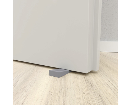 Butoir de porte gris en caoutchouc devant une porte