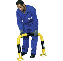 Une personne monte une barrière de protection en jaune et noir.