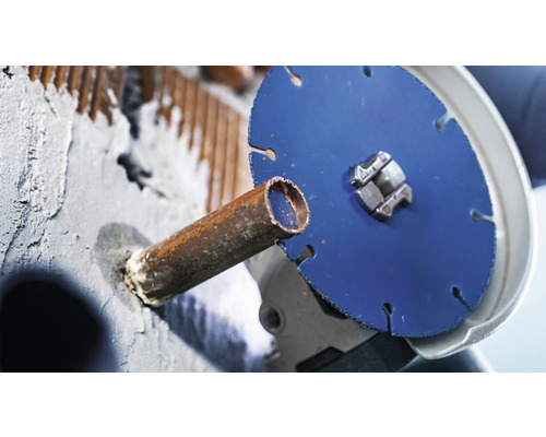 Un disque à tronçonner coupe un tuyau métallique.