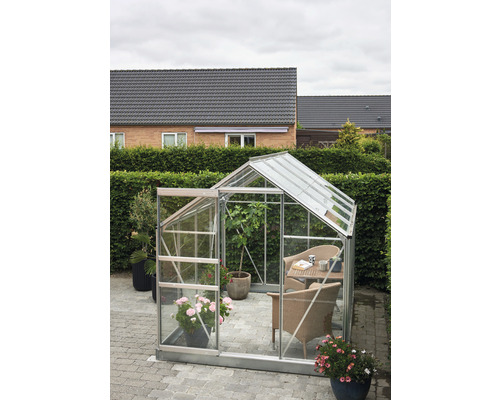 Serre avec porte ouverte et coin salon dans le jardin